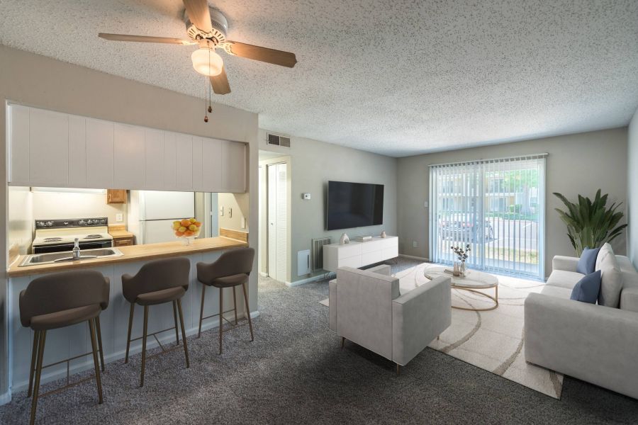 Modern living room with a sofa, armchair, TV, bar stools, and sliding glass door to a patio.