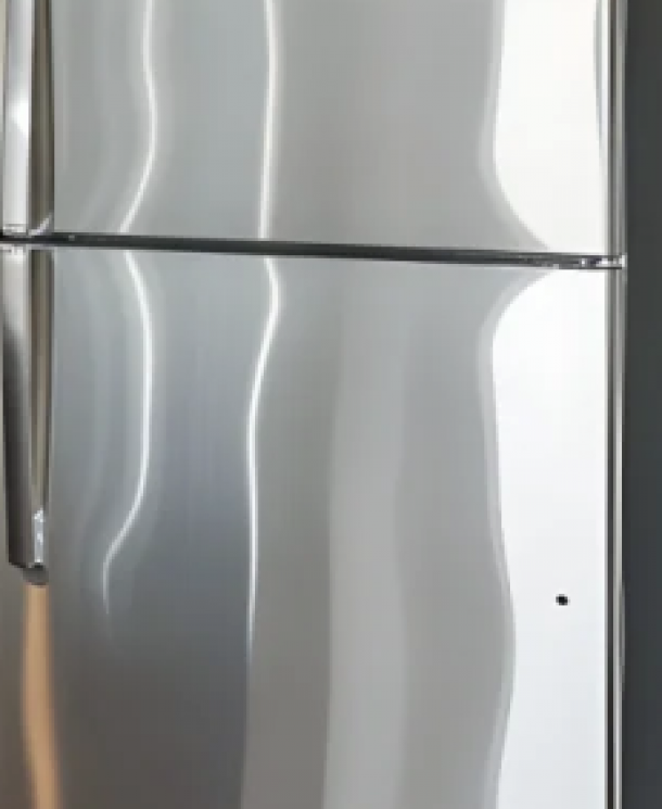 The Amber at Greenbrier A stainless steel refrigerator with a top freezer and sleek, vertical handles.