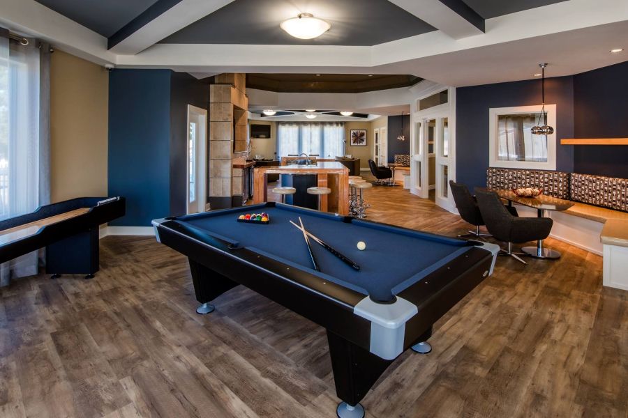 The Amber at Greenbrier Modern game room with a pool table, shuffleboard, seating area, and wooden flooring.